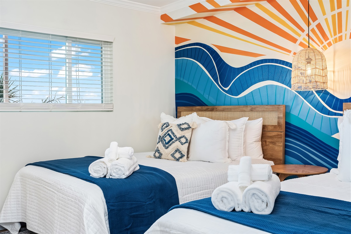 Vibrant guest bedroom with 2 queen beds.