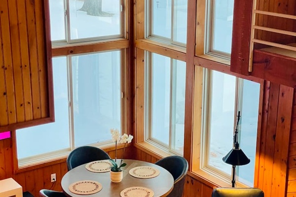 Beautiful breakfast nook surrounded by windows and lake views