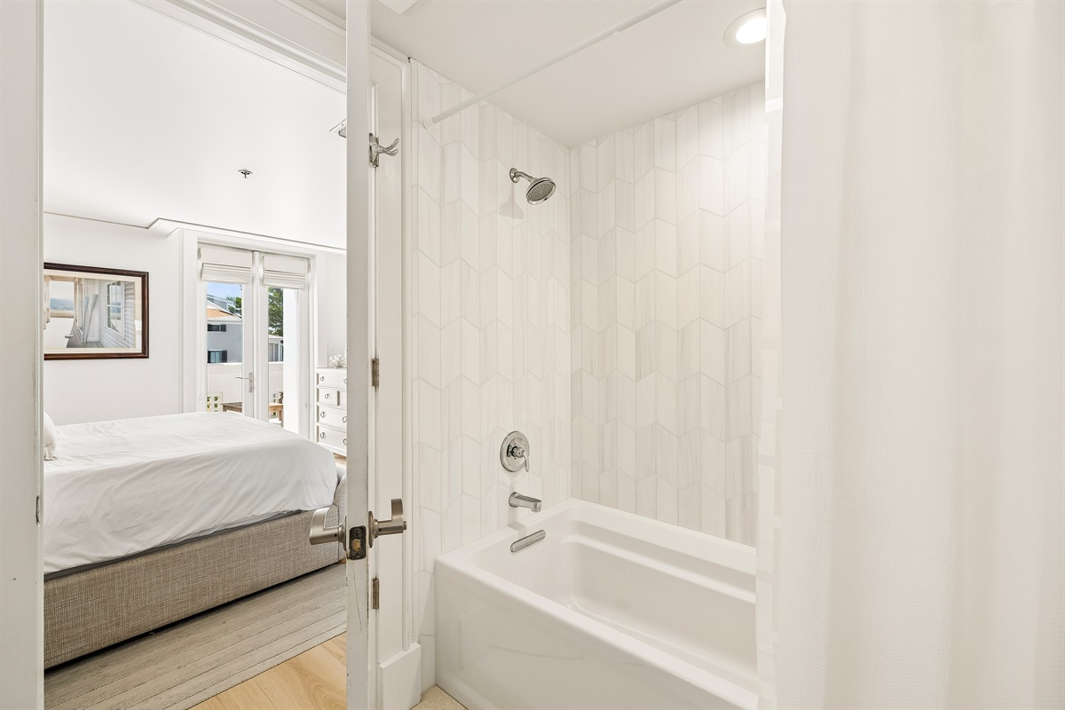 Primary Bathroom offers a large soaking tub and marble tilework.