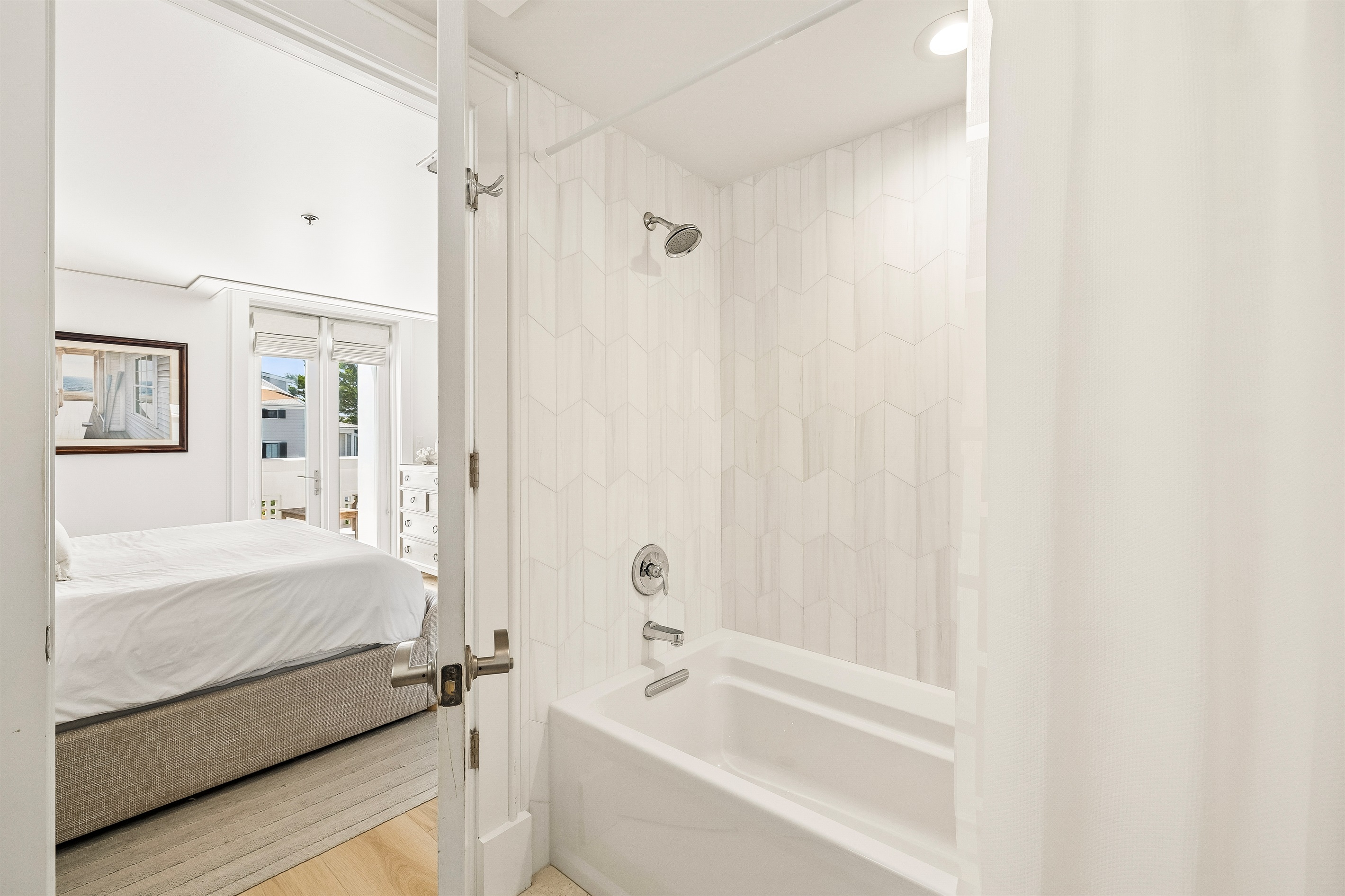Primary Bathroom offers a large soaking tub and marble tilework.