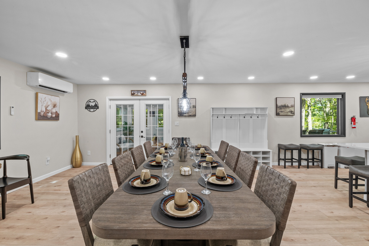 Light fixtures cast a warm glow over the dining table, where comfortable chairs invite guests to linger