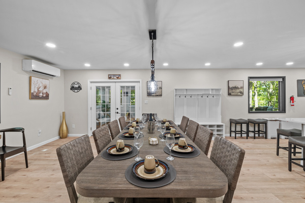 Light fixtures cast a warm glow over the dining table, where comfortable chairs invite guests to linger