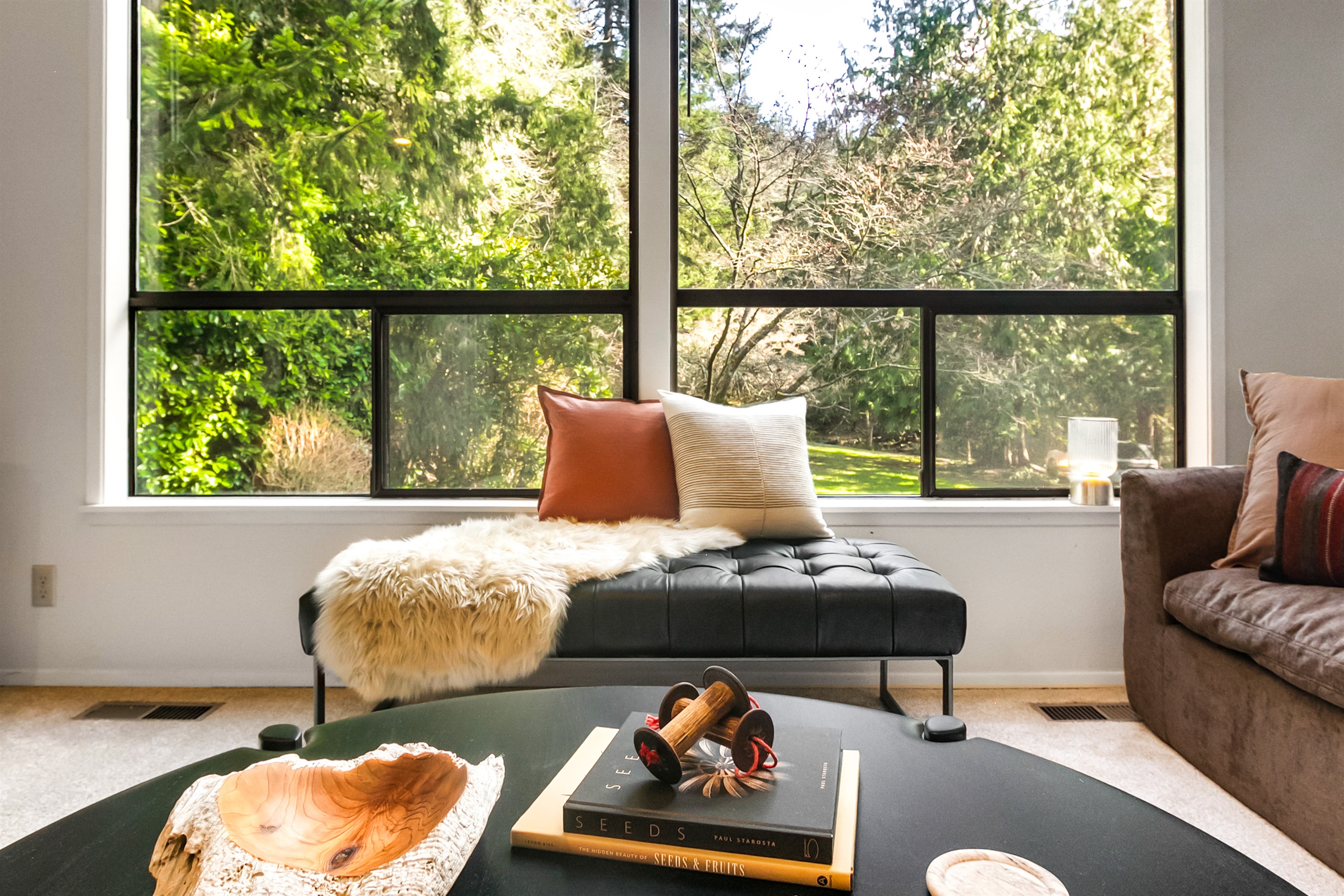 A large round coffee table in the living room is the perfect stage for your charcuterie and cheese plate. Play games or share snacks while enjoying the forest view.