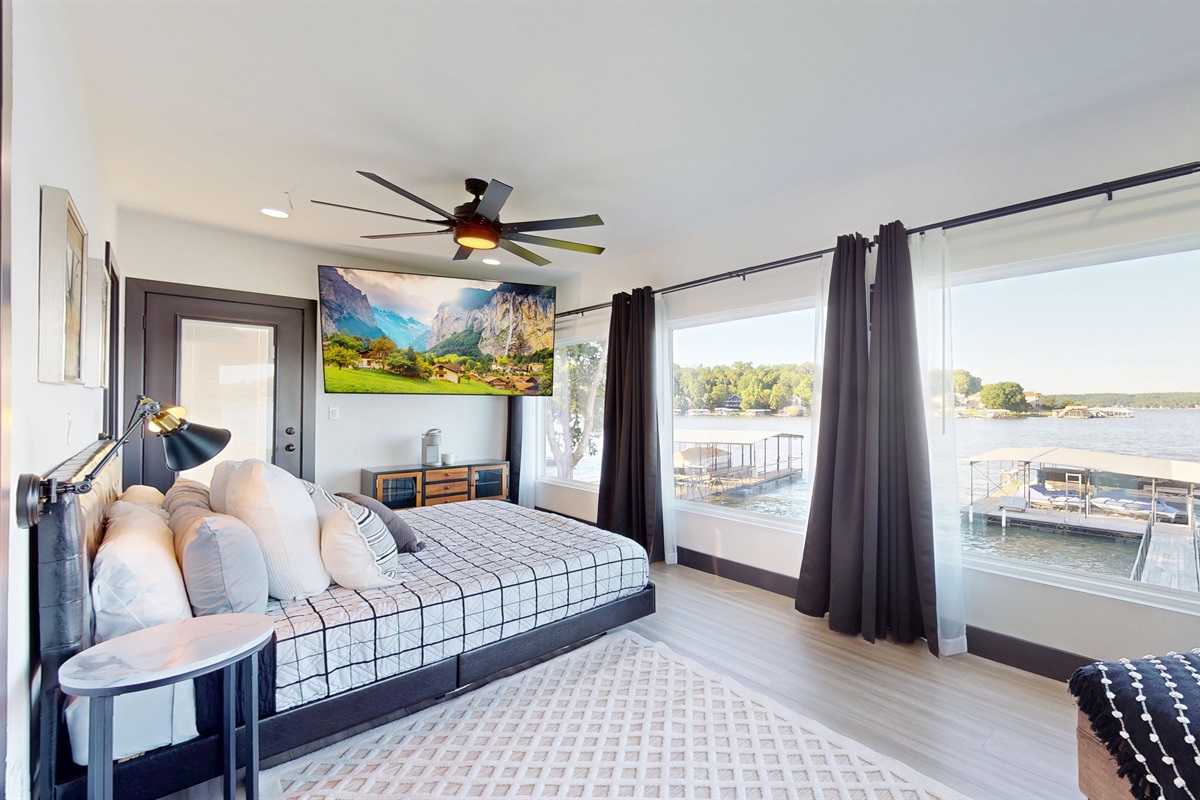Primary Bedroom has king bed with an ensuite bathroom, 85" TV, Keurig coffee maker, and private balcony access.