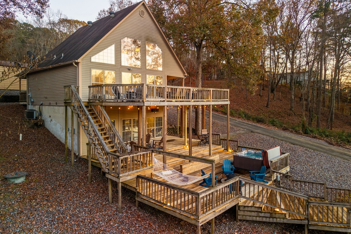 A wide look at the home reveals its stunning multi-level decks and beautiful lakeside placement, making every angle feel picture-perfect.