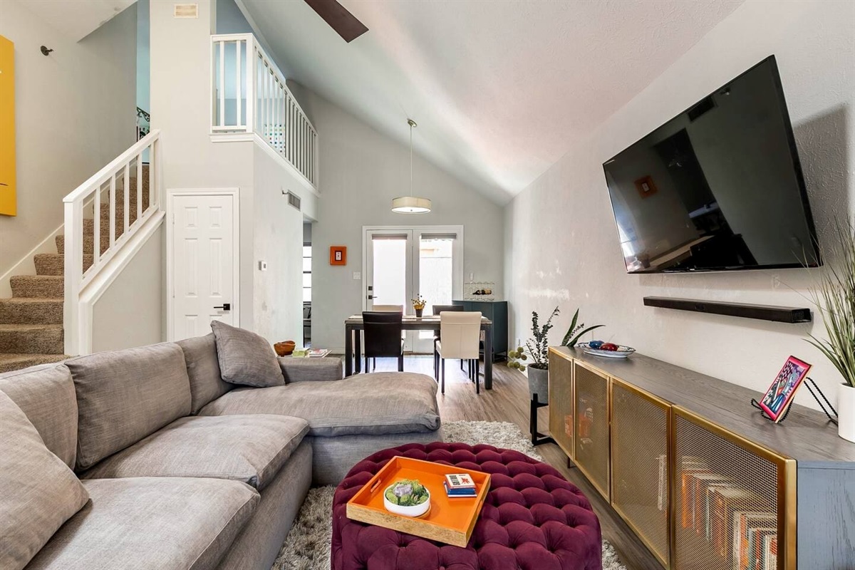 Living room with mounted flat-screen TV and cozy seating.