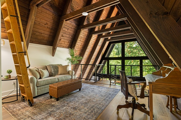 A serene view of the backyard can be seen from the loft. In addition to the sofa bed, there is also a desk that can serve as a dedicated working space if needed.