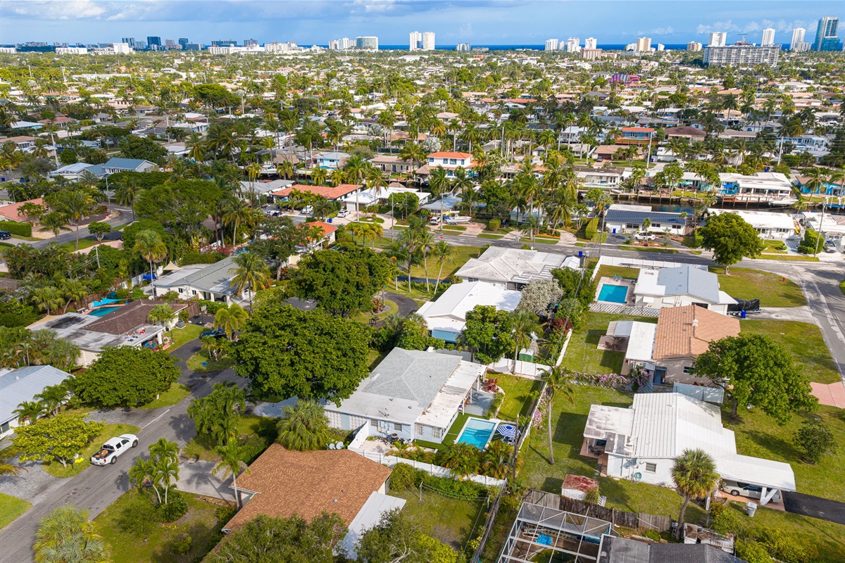 Soaring aerial perspectives highlight the home’s tranquil Pompano Beach neighborhood, private backyard oasis, covered carport, and extended driveway with space for 3 cars.