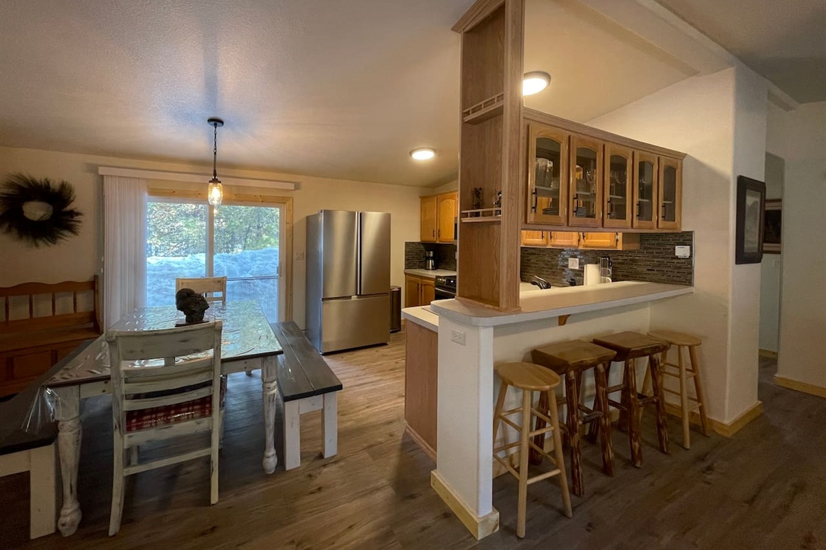 Kitchen with Updated Appliances, Backsplash, Faucet, Cupboard Door Handles, Light, Table, and Flooring
