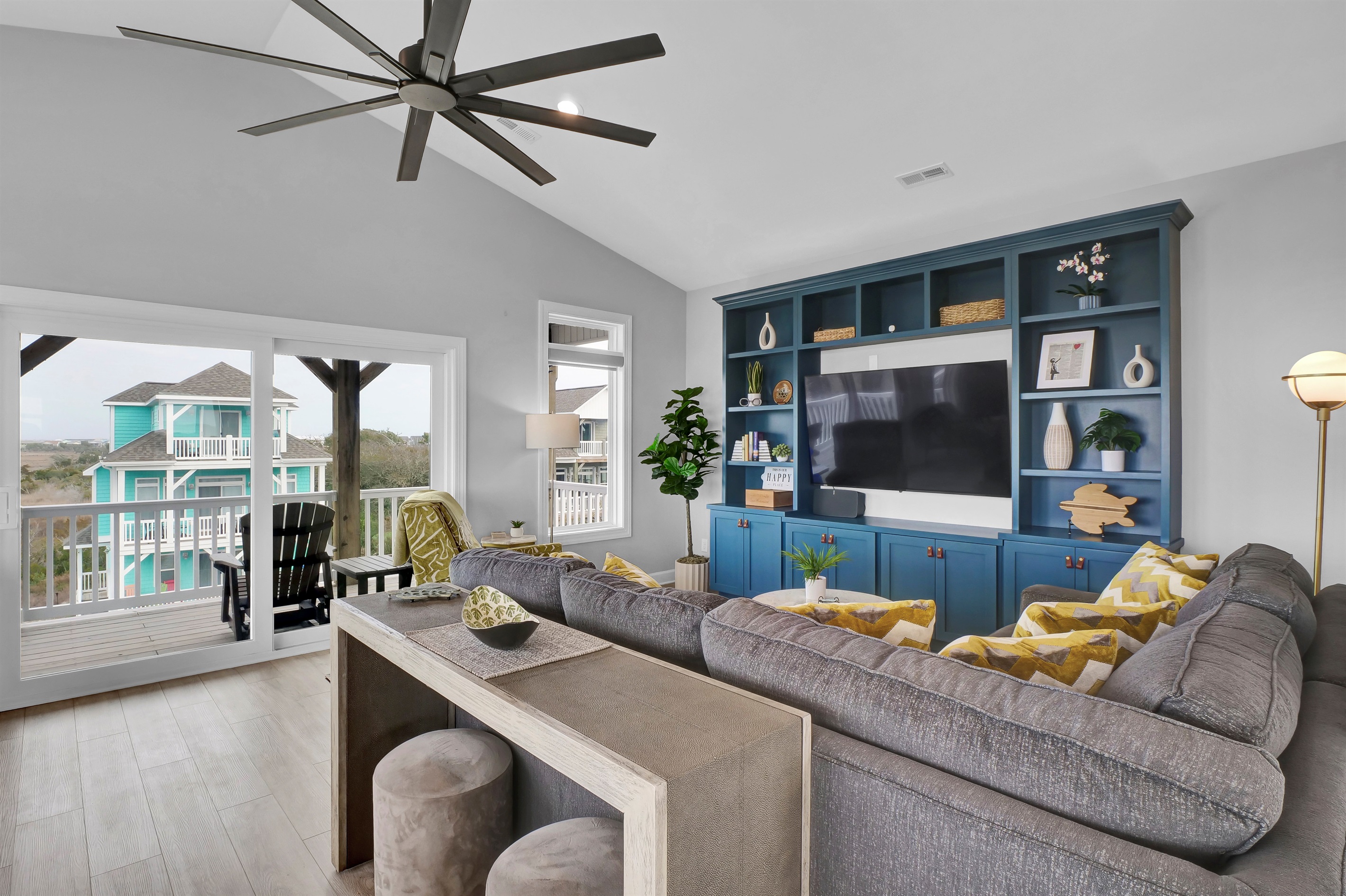 Kick back and relax in the airy living area, featuring a comfy sectional, recliner, and Smart TV—perfect for movie nights, casual lounging, or unwinding after a sun-filled beach day