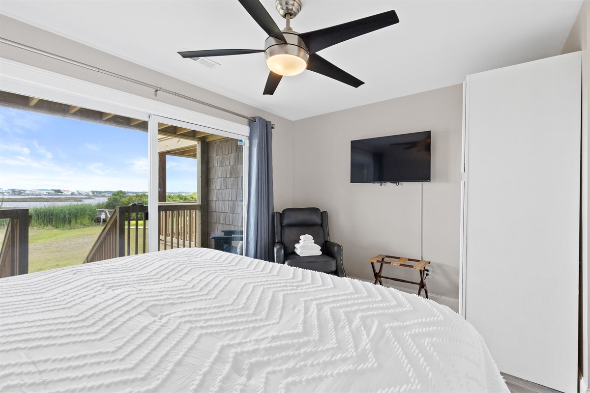 Cozy king suite with smart TV, seating area, and natural light