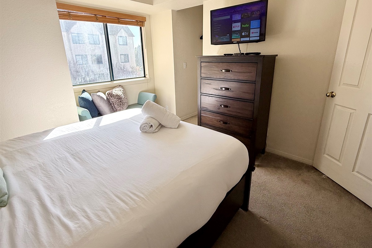 Queen Bedroom with walk in closet, dresser and wall mounted smart tv and cable tv.