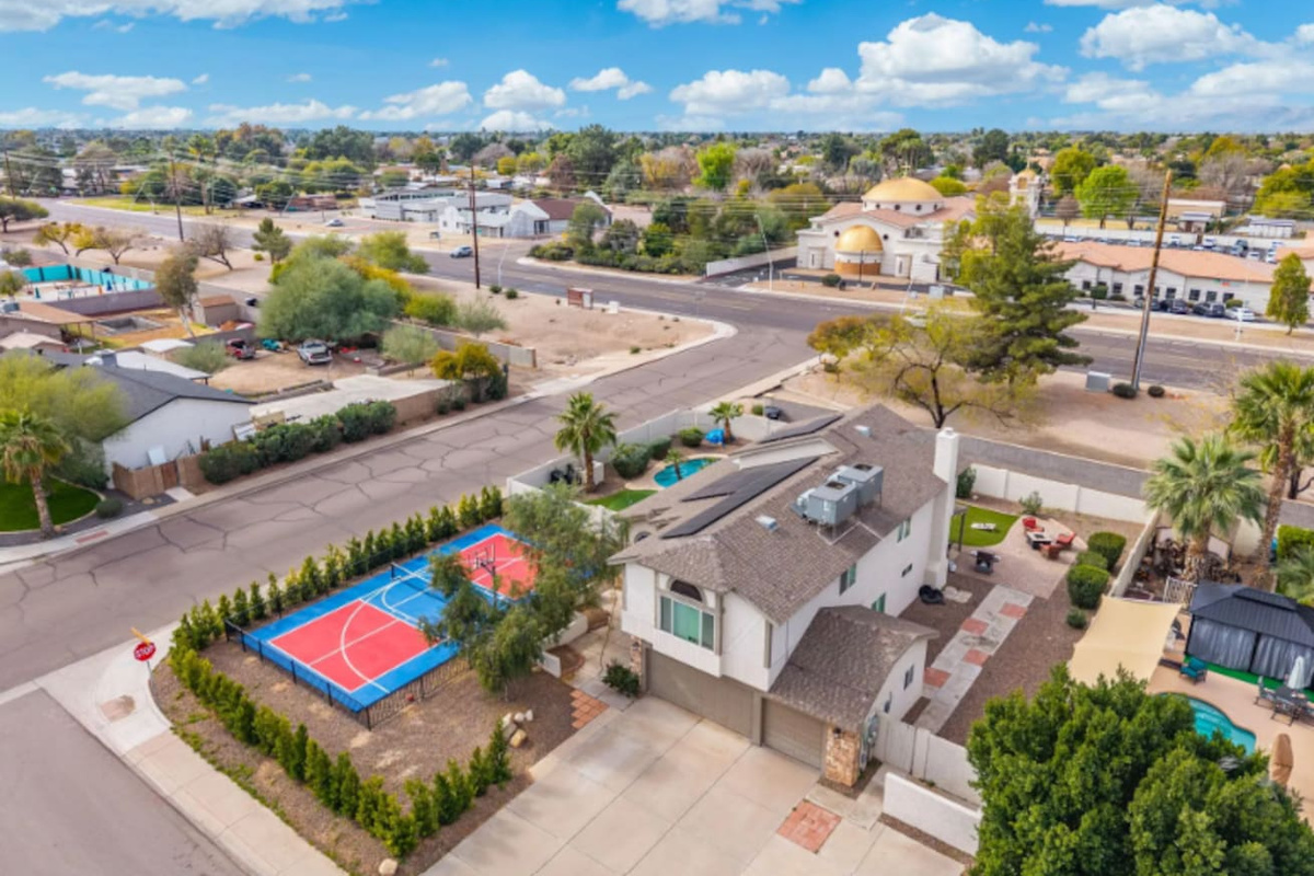 Contemporary home with dedicated sports court, pool, and manicured grounds in established neighborhood.