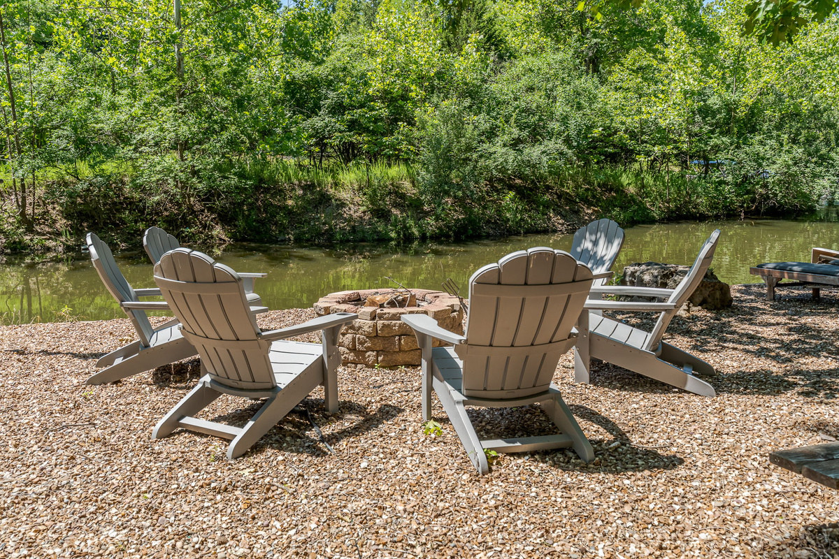Gather the whole crew at the fire pit — picnic table for dinner, Adirondack chairs for after, and the lake just down the path.