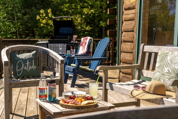 Enjoy your morning coffee or evening refreshments on the cozy outdoor deck, complete with comfortable seating and a tranquil forest setting.