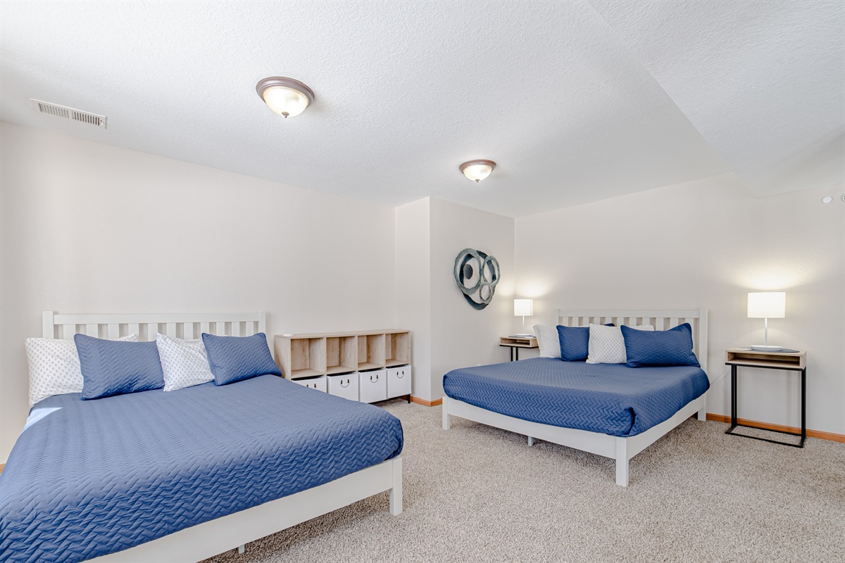Downstairs sleep space features 2 queen beds, blackout curtains and a private outdoor entrance.