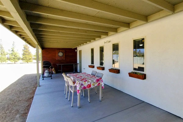 Outdoor patio dining area with grills, darts, smart tv and more seating