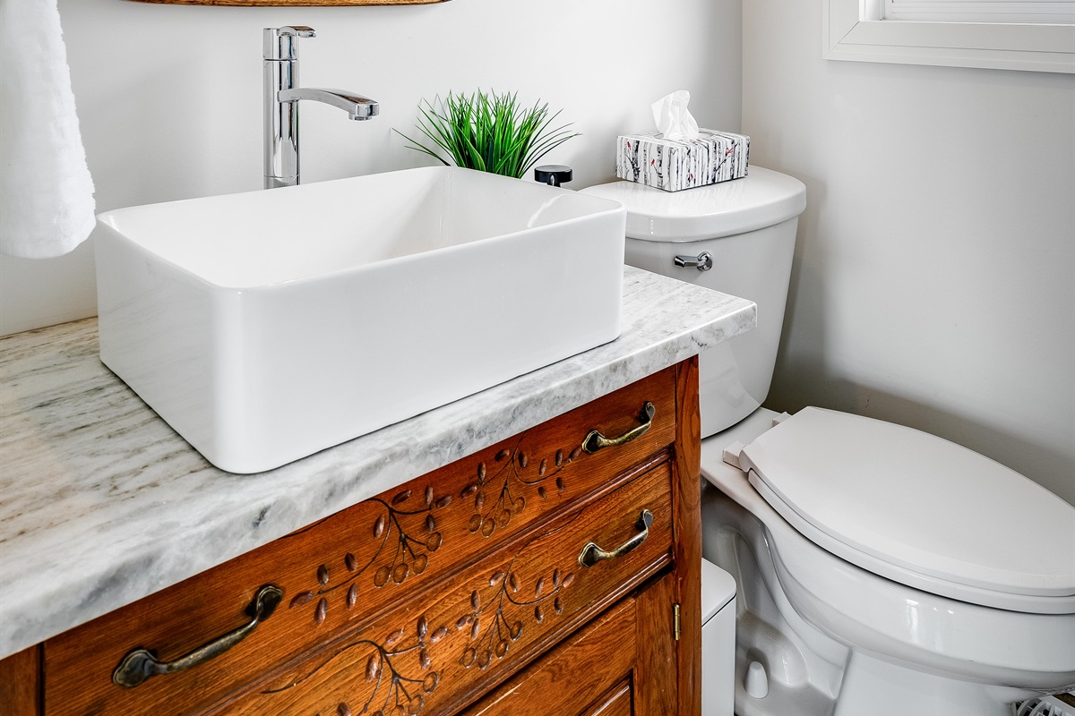 Half Bathroom with Wood accents root the space, bringing warmth to purity.