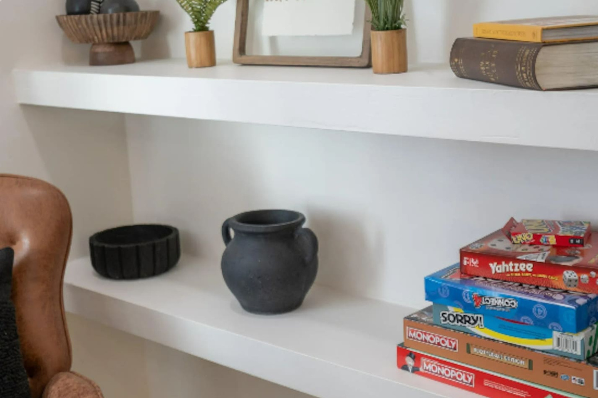 A curated shelf mixes decorative touches with classic board games, a small reminder that there's always something fun within reach.