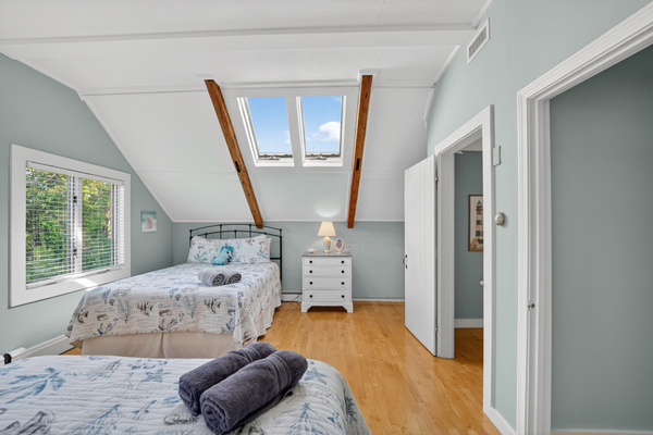 Bright upstairs sleeping area featuring comfortable accommodations, skylights, and an airy open layout.