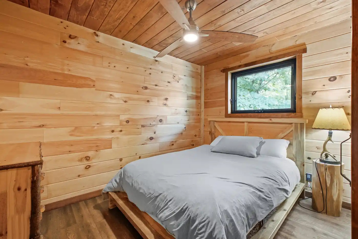 Cozy bedroom with warm wood-paneled walls