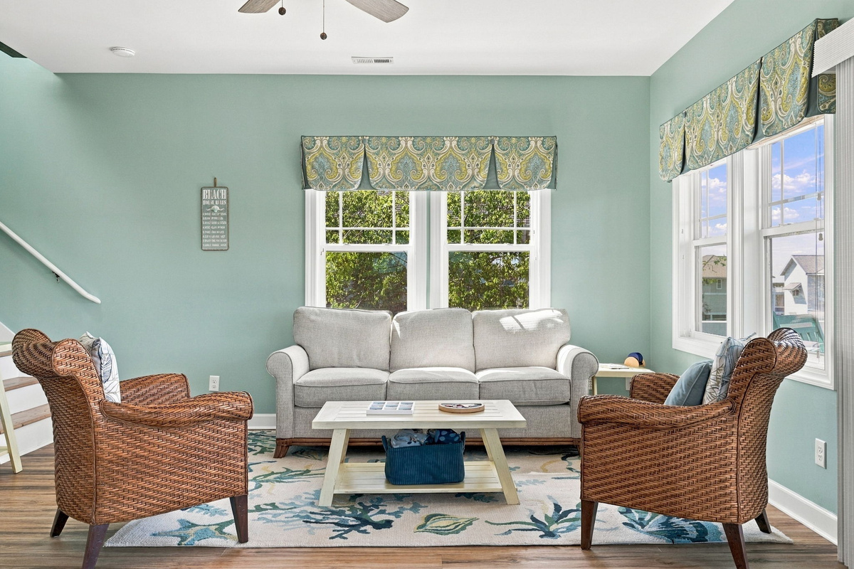The perfect spot for conversation, games, or movie nights with comfortable sofas and charming wicker accent chairs