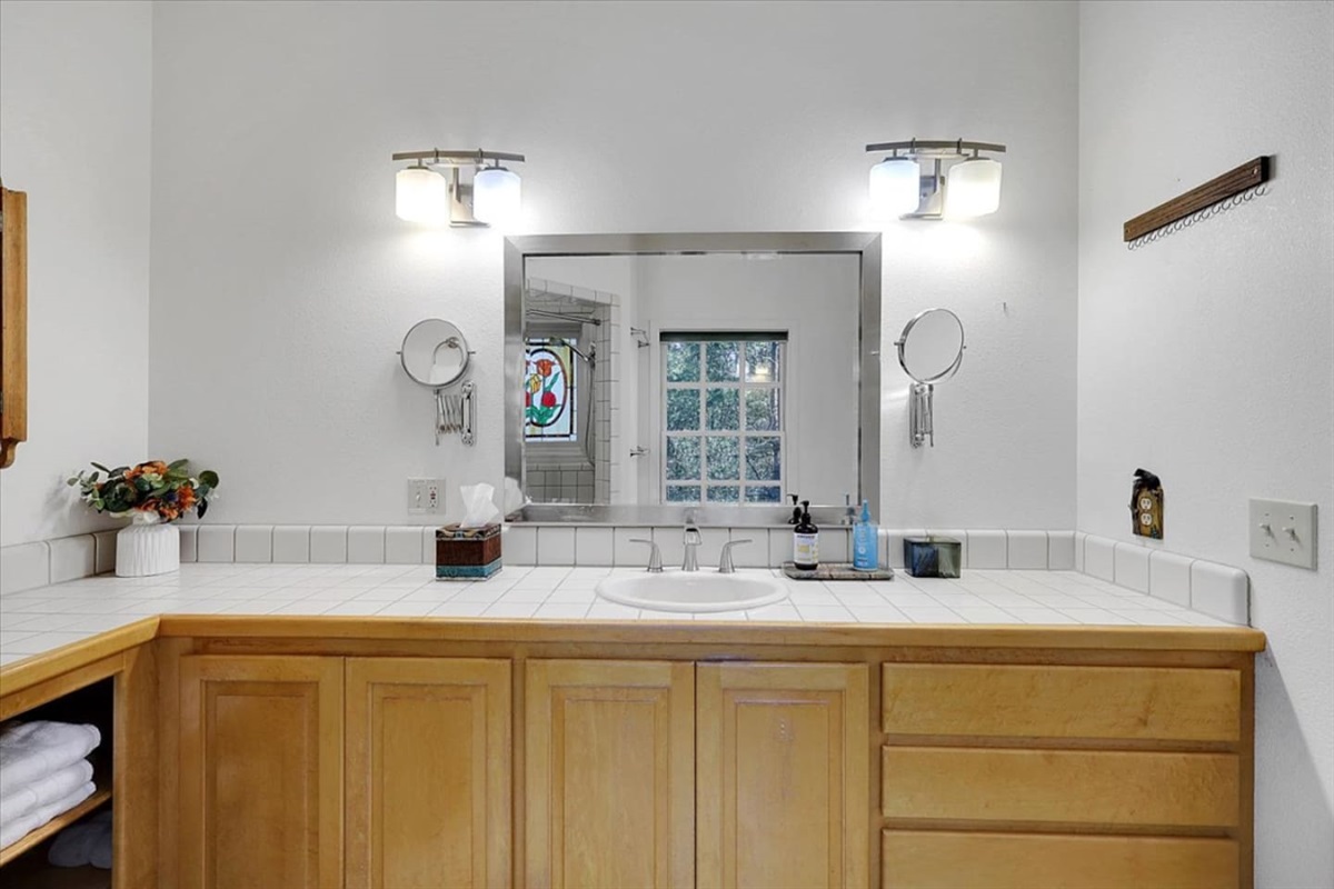 Full Bathroom 1 vanity with wide counter space, cabinet storage, and guest essentials by the sink.
