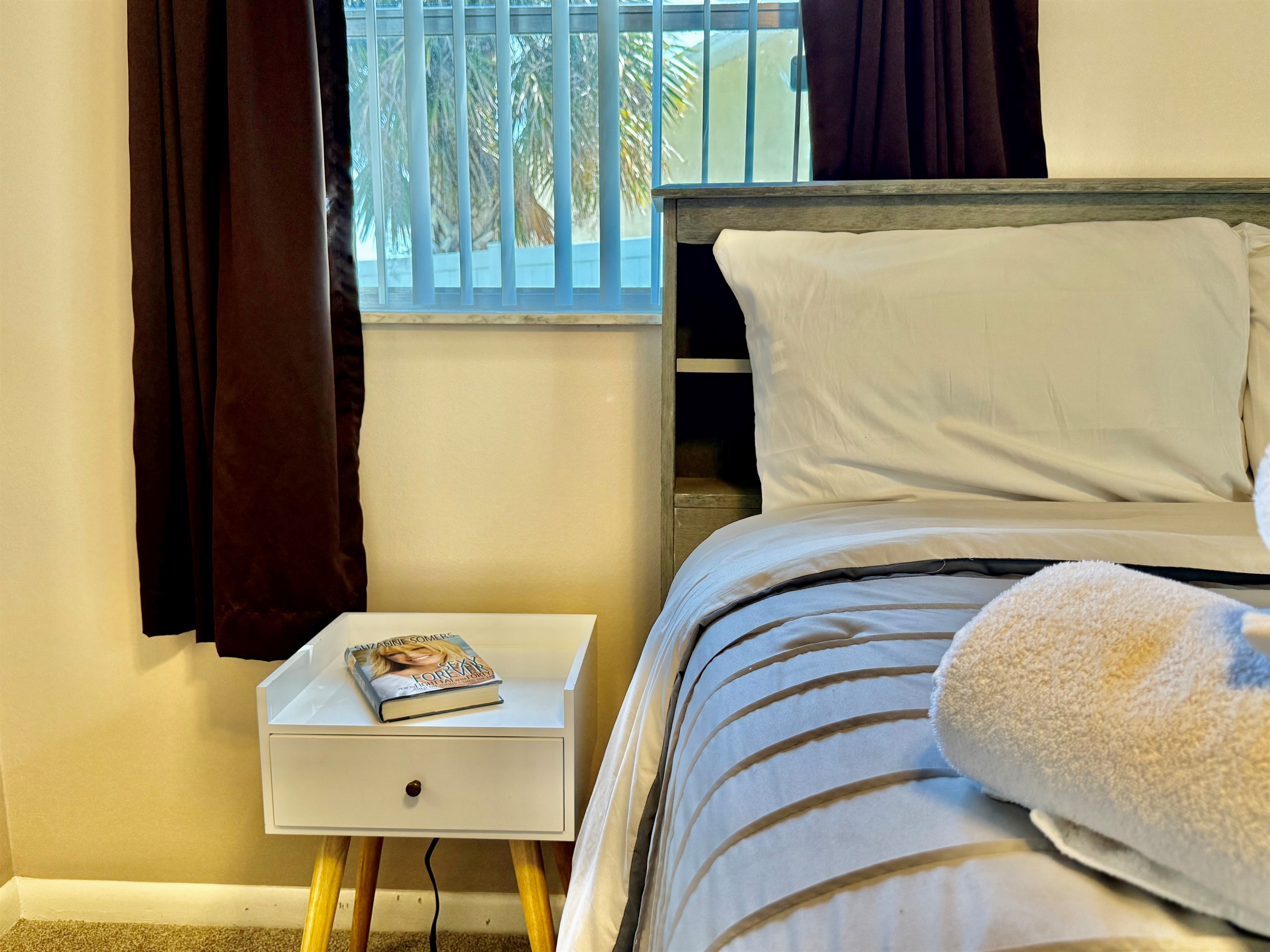 From the comfortable bedding to the modern ceiling fan and calming color palette, this space is designed for true rest and relaxation.