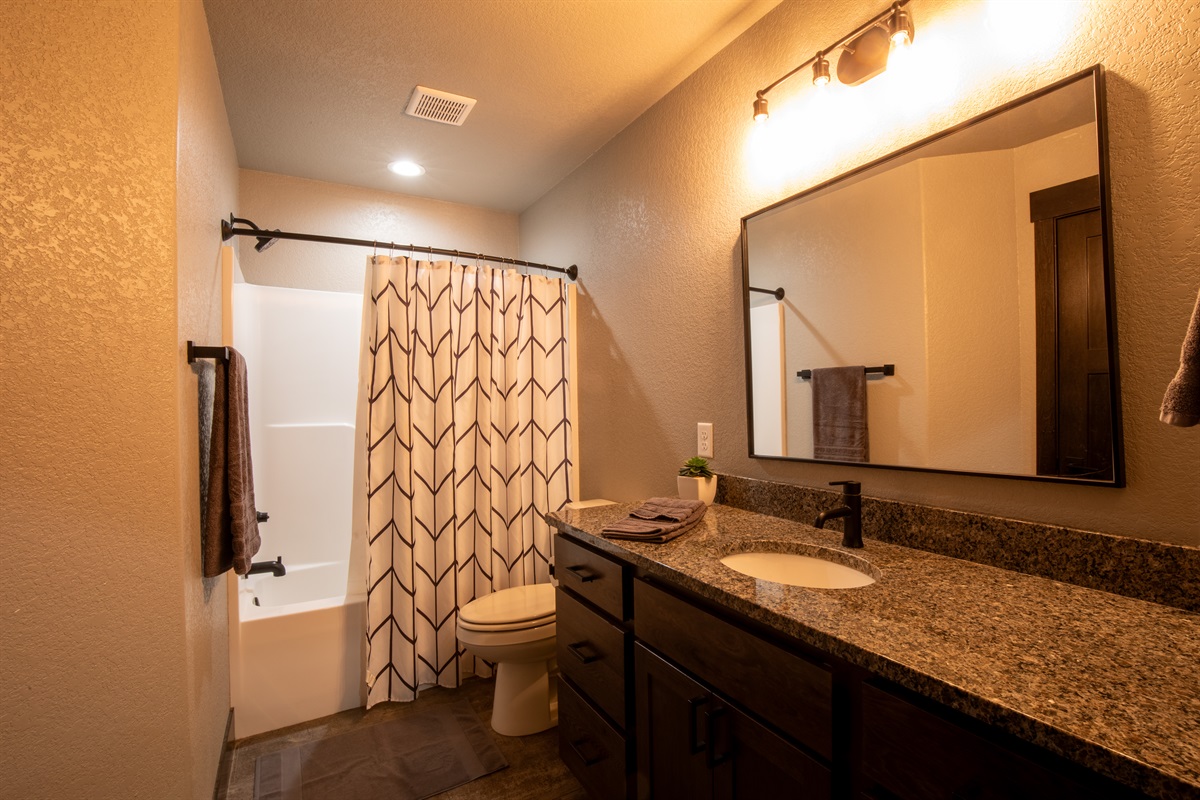 This main floor full bath offers a spacious granite vanity, bright lighting, and a shower/tub combo—perfect for freshening up after a day on the trails.