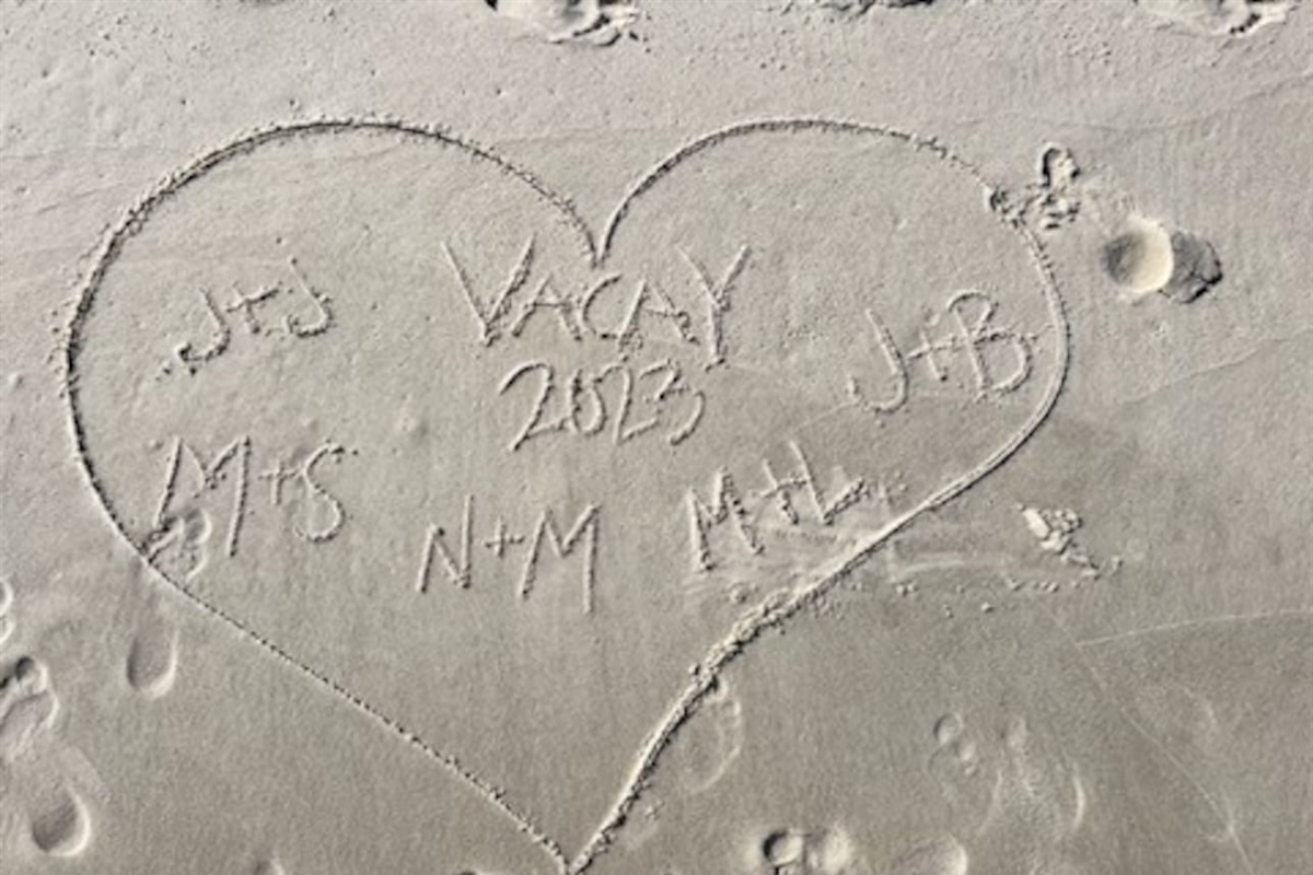Beach vibes: Heart in sand marking 2023 love, memories, and connections.