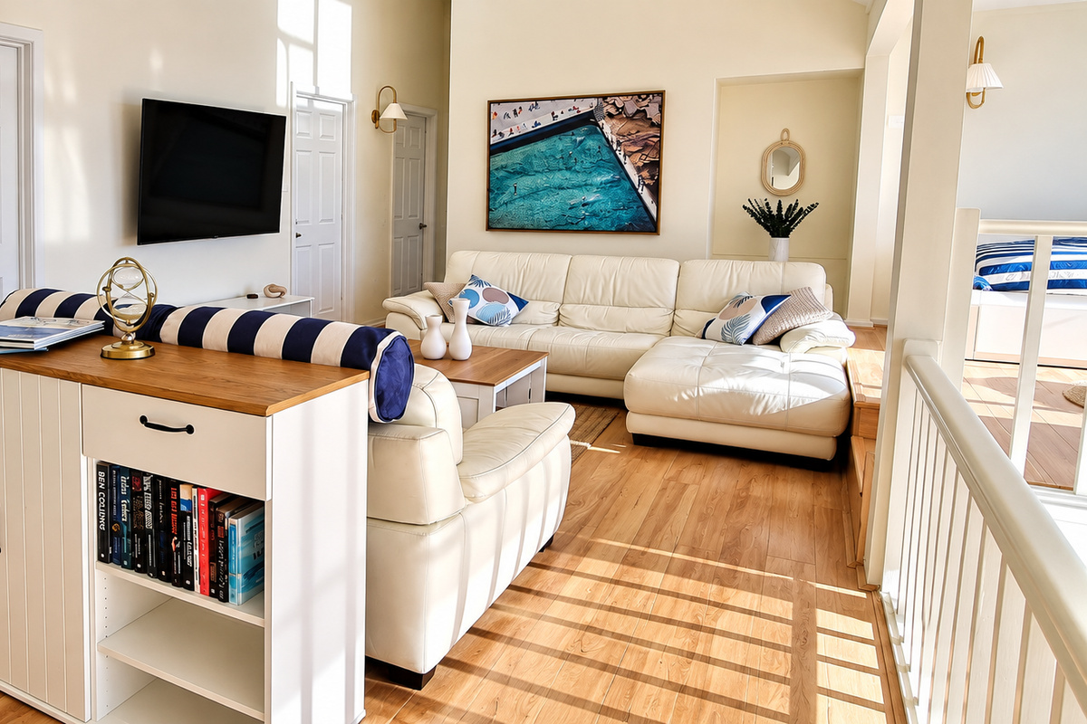 Bright and inviting lounge with comfortable leather seating, a large wall-mounted TV and plenty of space to unwind.