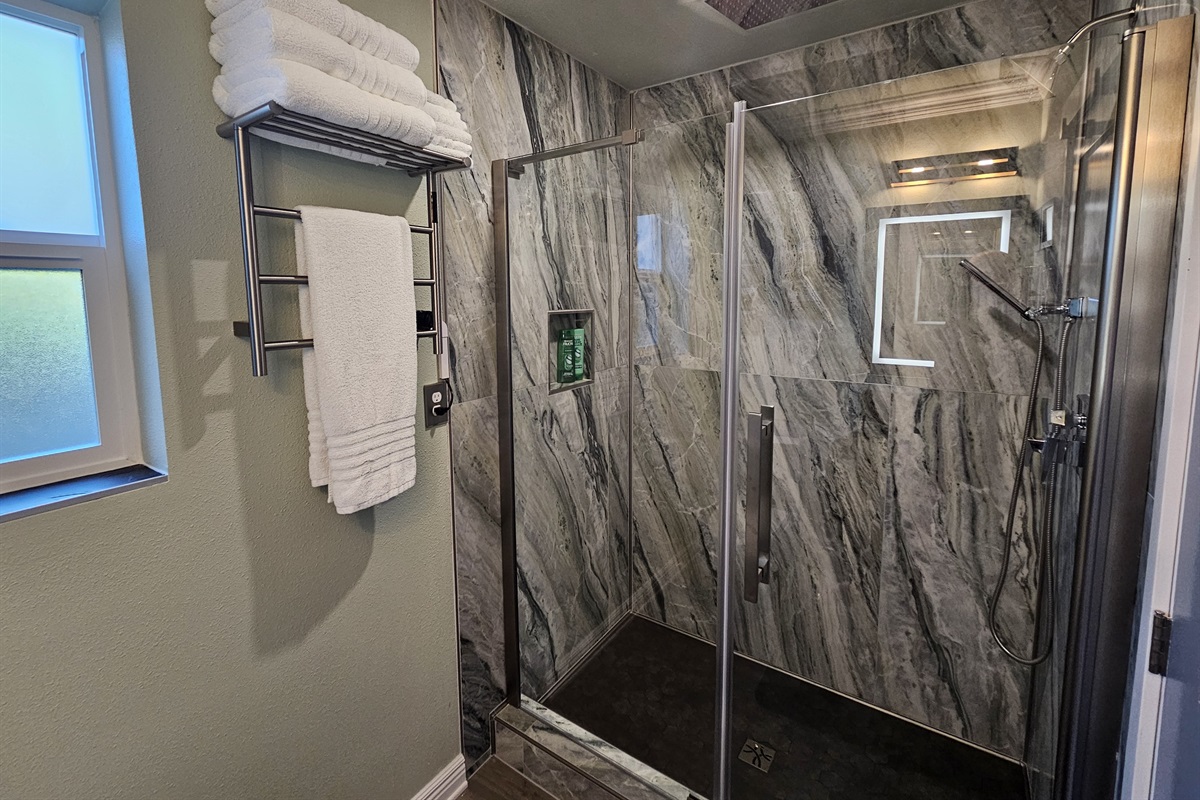 Italian onyx-inspired shower with 4 showerheads (standard, rain, and handheld) creates a spa-like atmosphere.