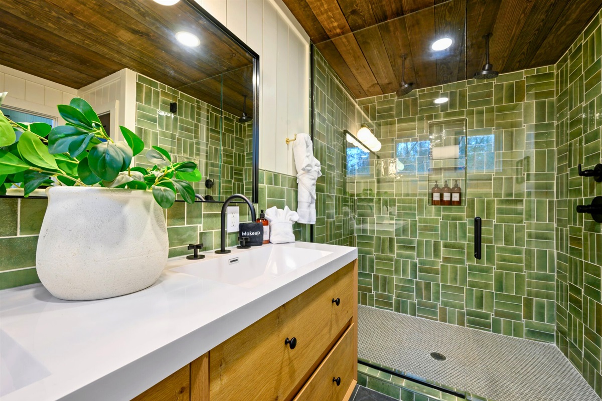 Natural wood tones and greenery bring warmth and liveliness to this well-designed bathroom.