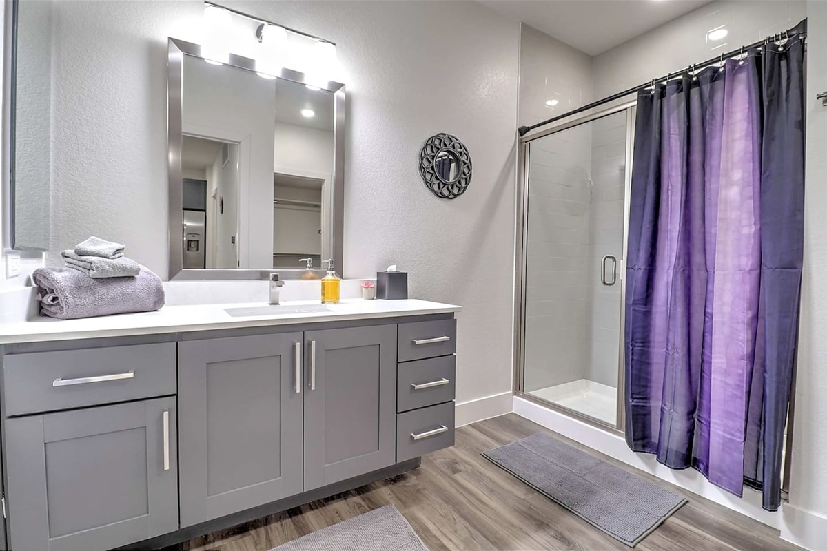 - Refresh in a stylish bathroom with gray cabinets and glass shower doors   - Bright lighting and soft towels create a comfortable, clean retreat   - Everything you need for a relaxing routine after a long day out