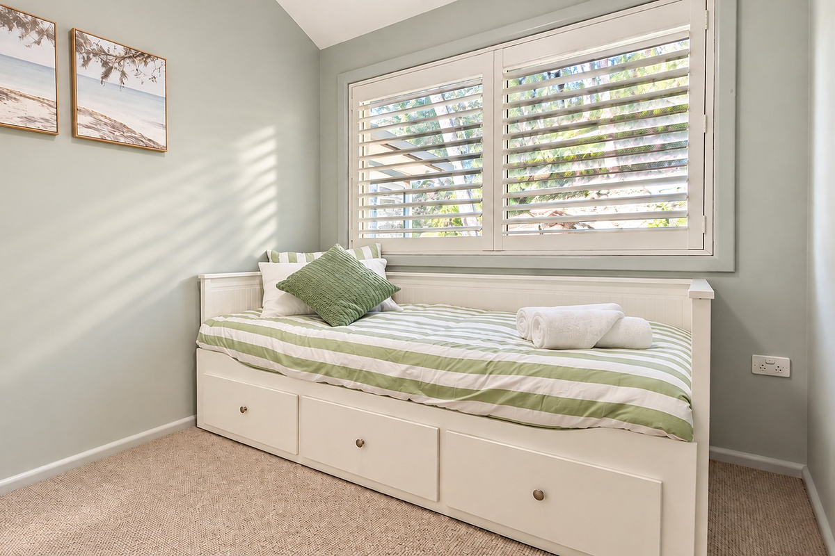Natural light and calming coastal colours make this charming single bedroom feel bright and inviting.