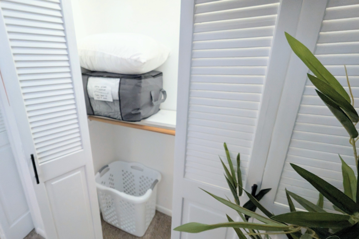 The second closet is stocked with a laundry basket, plus extra blankets and pillows for added comfort. 