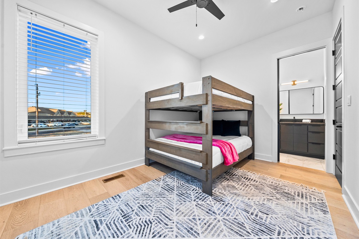 A warm and inviting bunk room with natural wood tones, generous sleeping space, and playful details that add charm and personality.