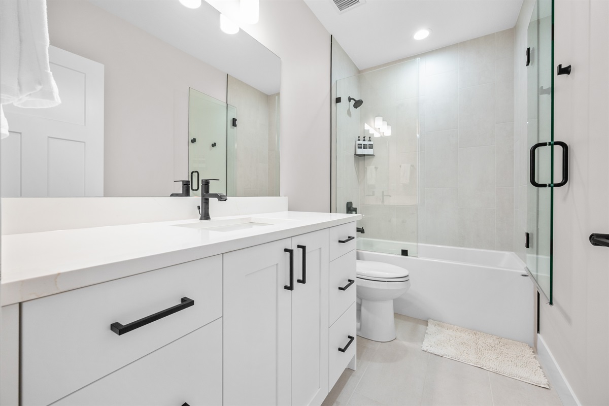 Lower-Level Hall Bath with double vanity and tub/shower combo for group convenience.