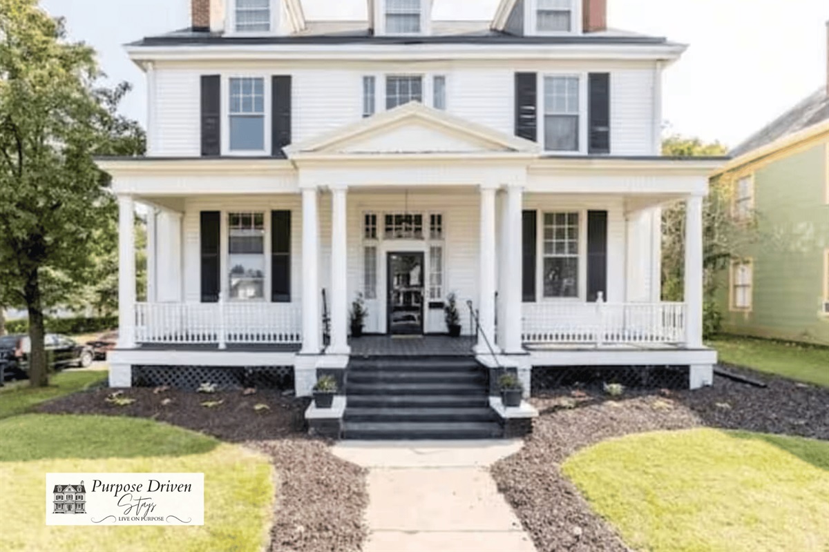 Stunning historic Victorian with beautiful front porch and rocking chairs.