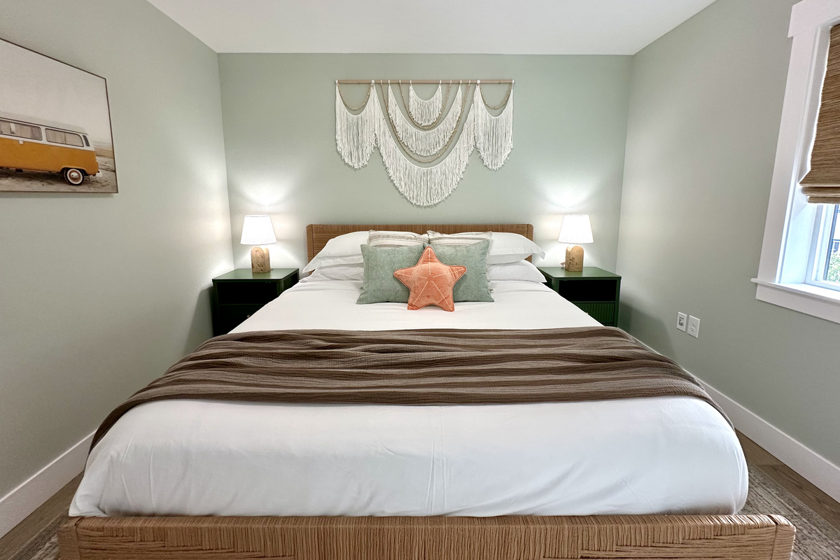 Layered bedding and soft lighting in the primary — restful nights after a full day on the sand.