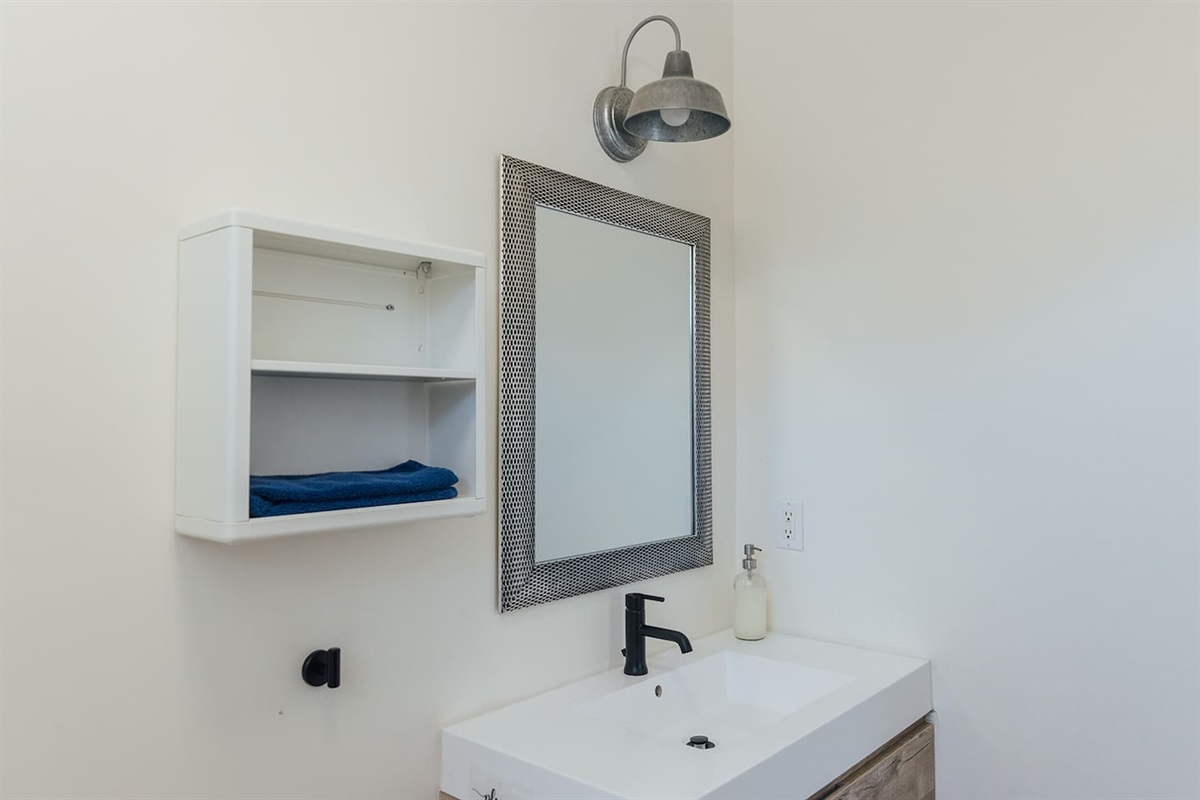Sink space with shelving and drawers for personal use.
