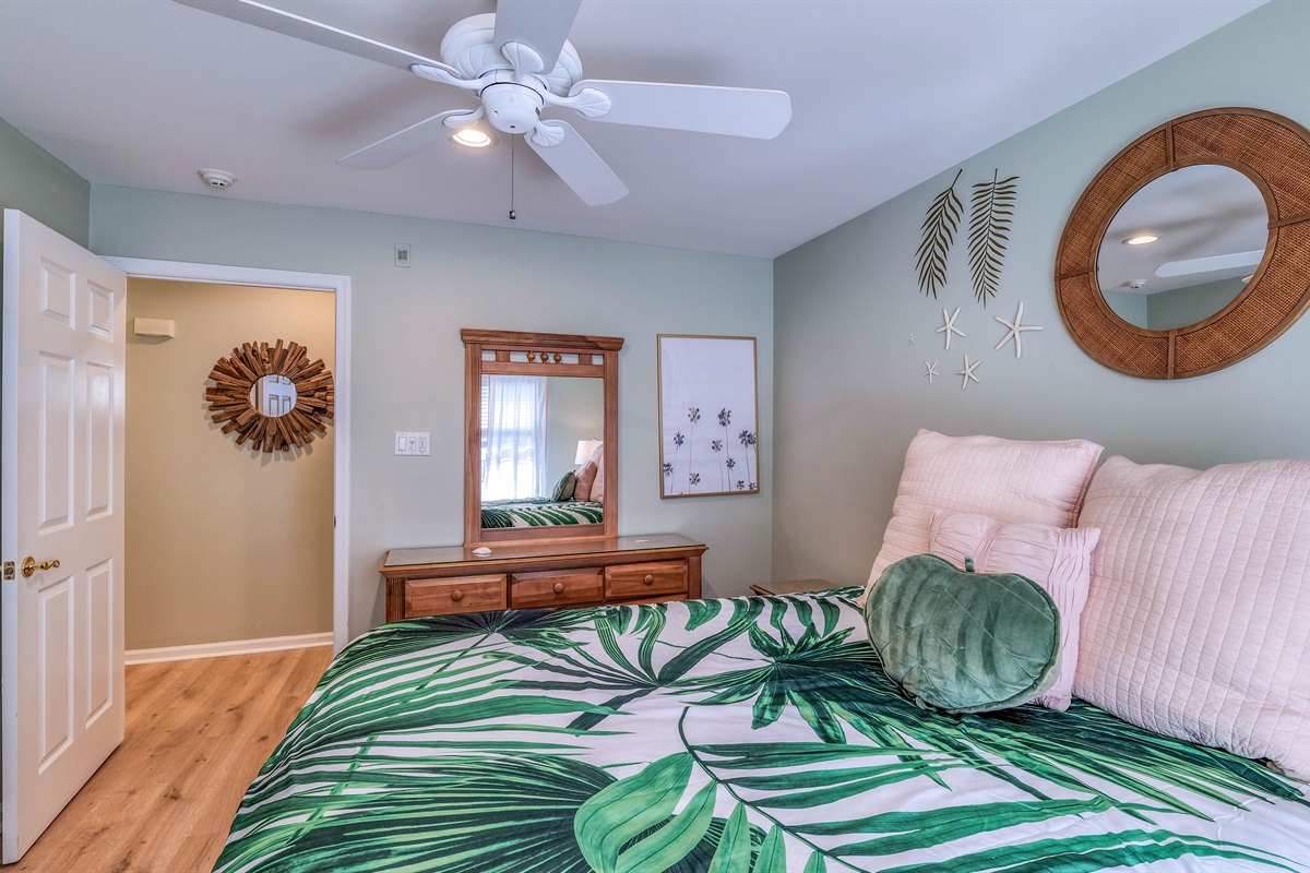 Queen sized bed with a dresser and TV