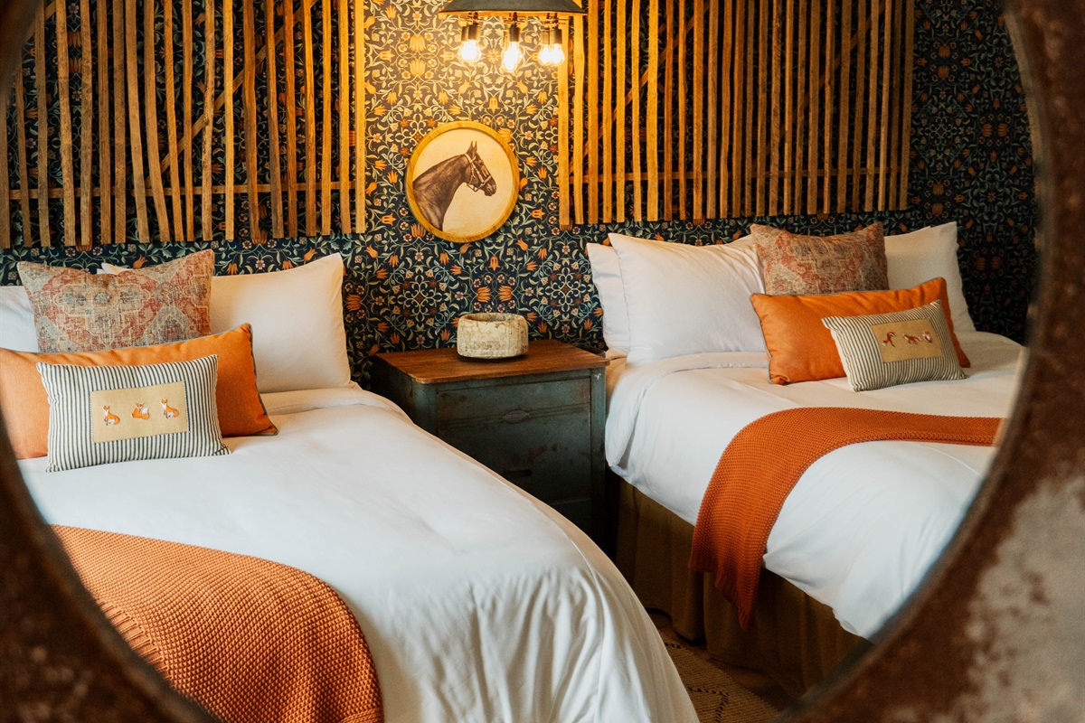 Inside the Corral Suite — a modern Western retreat with two queen beds, natural light, and designer finishes, upstairs on Wimberley Square.