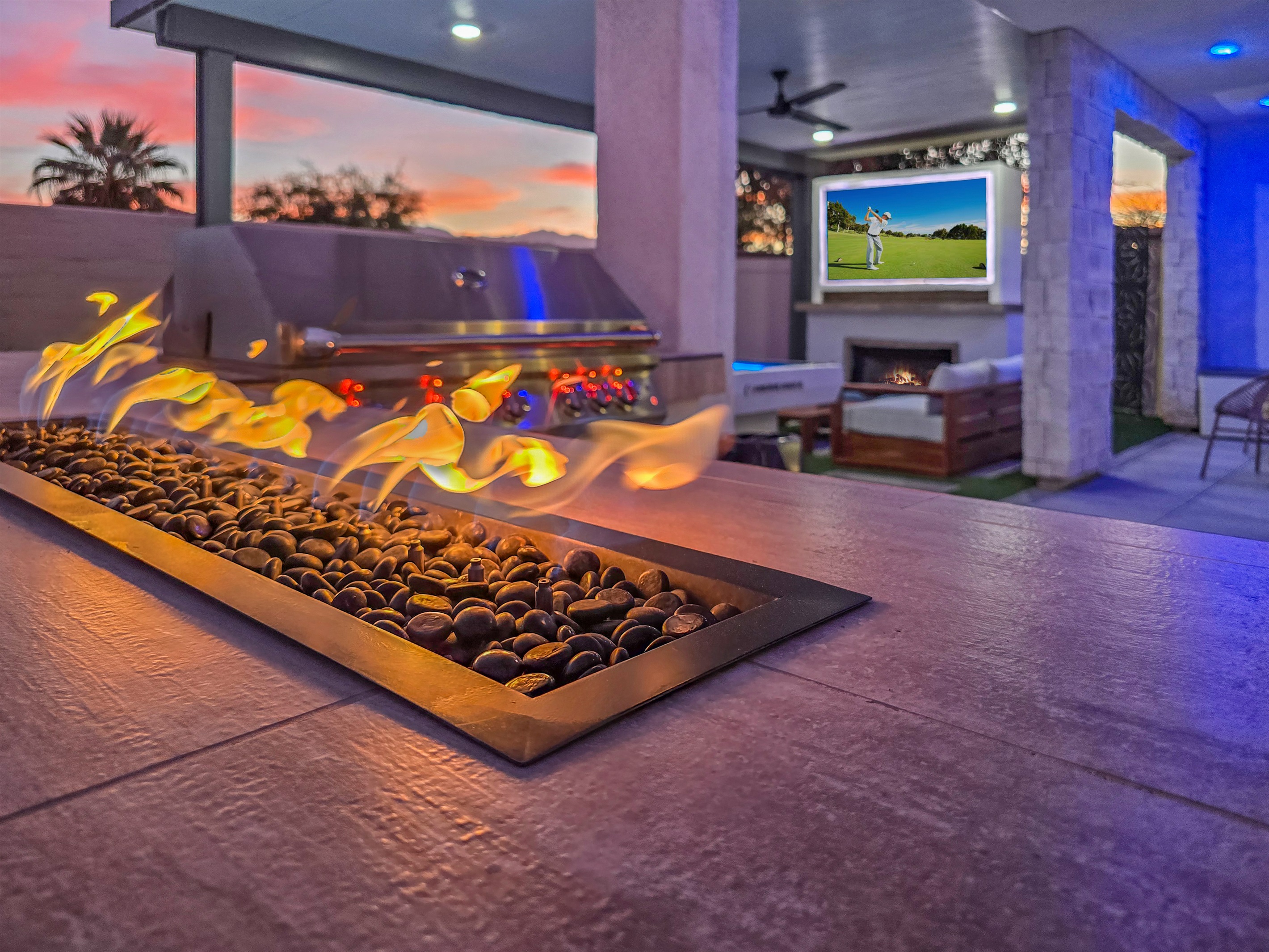 Outdoor island with natural gas BBQ, pizza oven, and tabletop fire feature.