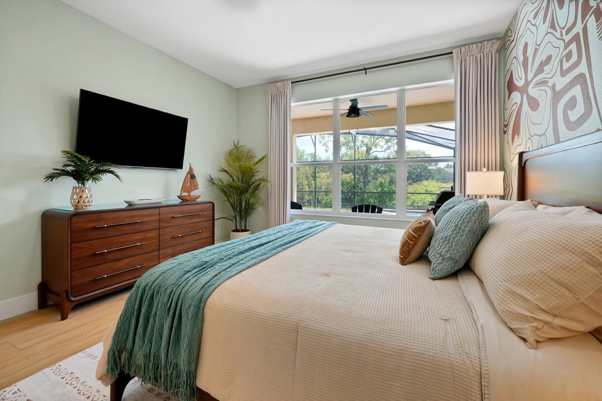 Moana King Suite: Main-floor king bedroom with ensuite, TV and peaceful views overlooking the pool and conservation area.