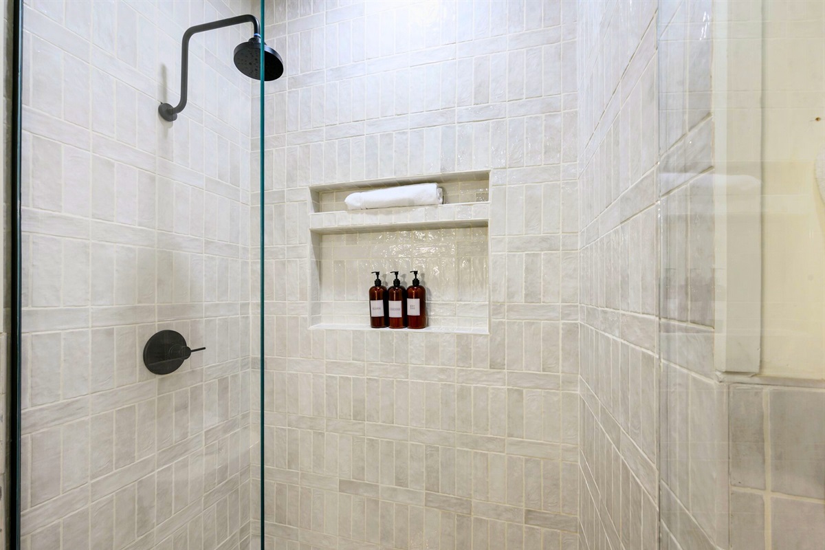 The walk-in shower features elegant tiling and a clean, modern design for an easy start to the morning.