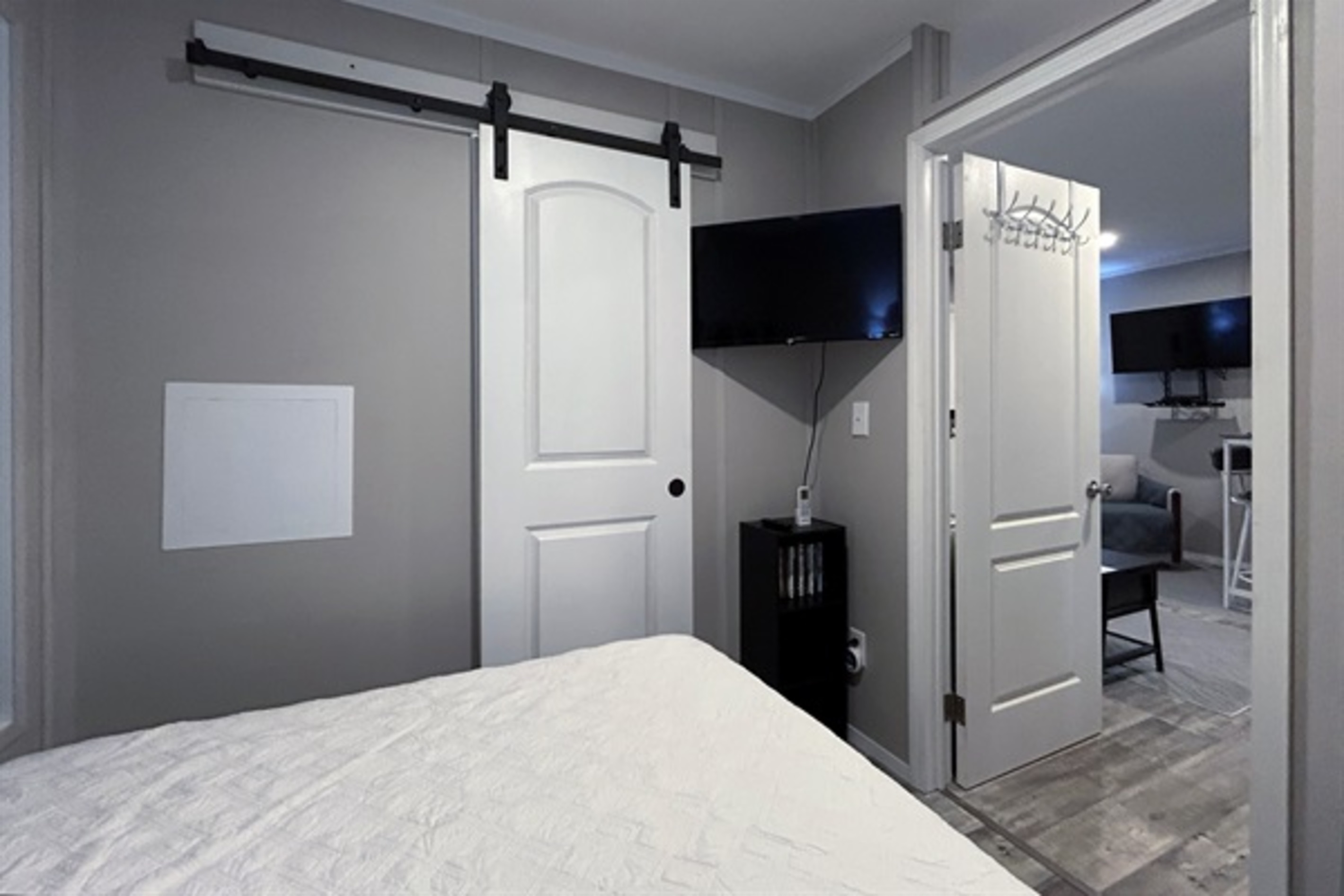 Bedroom #1 with queen bed, smart tv, en suite bathroom and hidden washer/dryer combo in closet