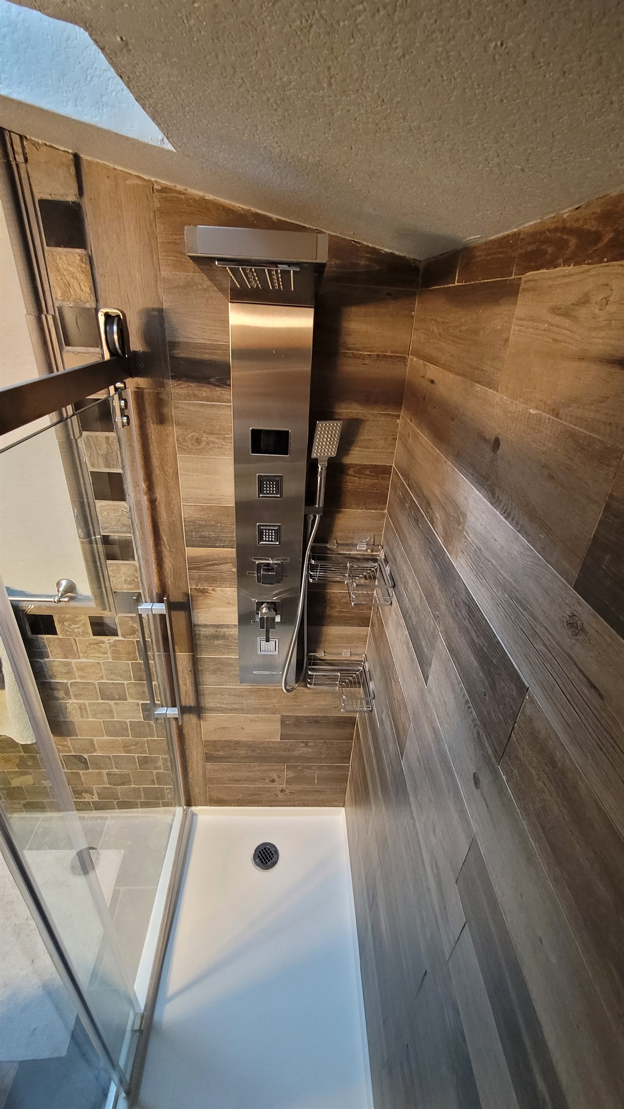 Guest Bath: Waterfall shower with body jets, blue light therapy, and hand held shower wand