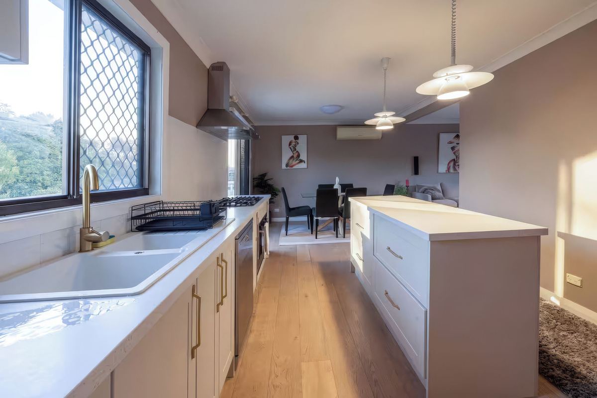 The kitchen at Luna’s Sanctuary features an island bench, gas cooktop, dishwasher, generous storage and direct flow to the dining and living spaces.