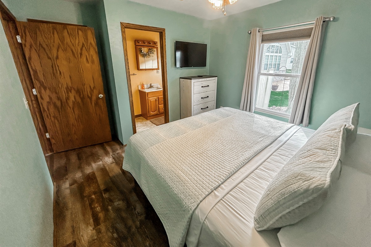 [Bedroom #1] King bed with TV and half bathroom.